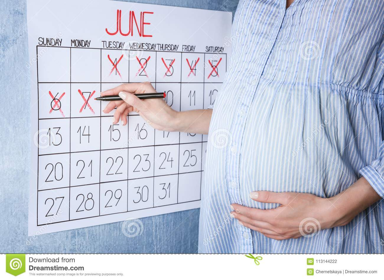 Young Pregnant Woman Counting Days With Calendar Stock