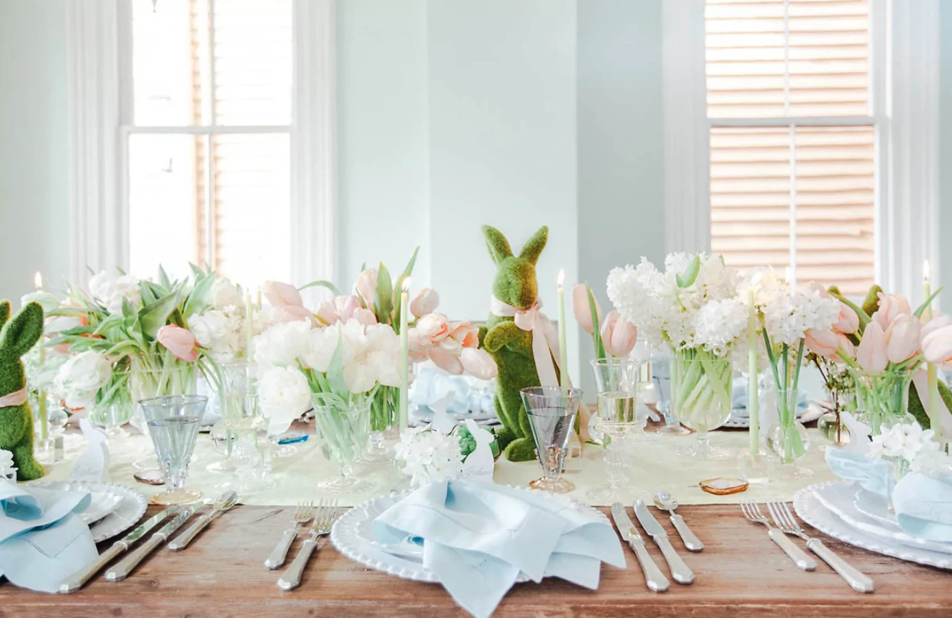Easter table setup decorated with fresh spring flowers colorful eggs and elegant place settings